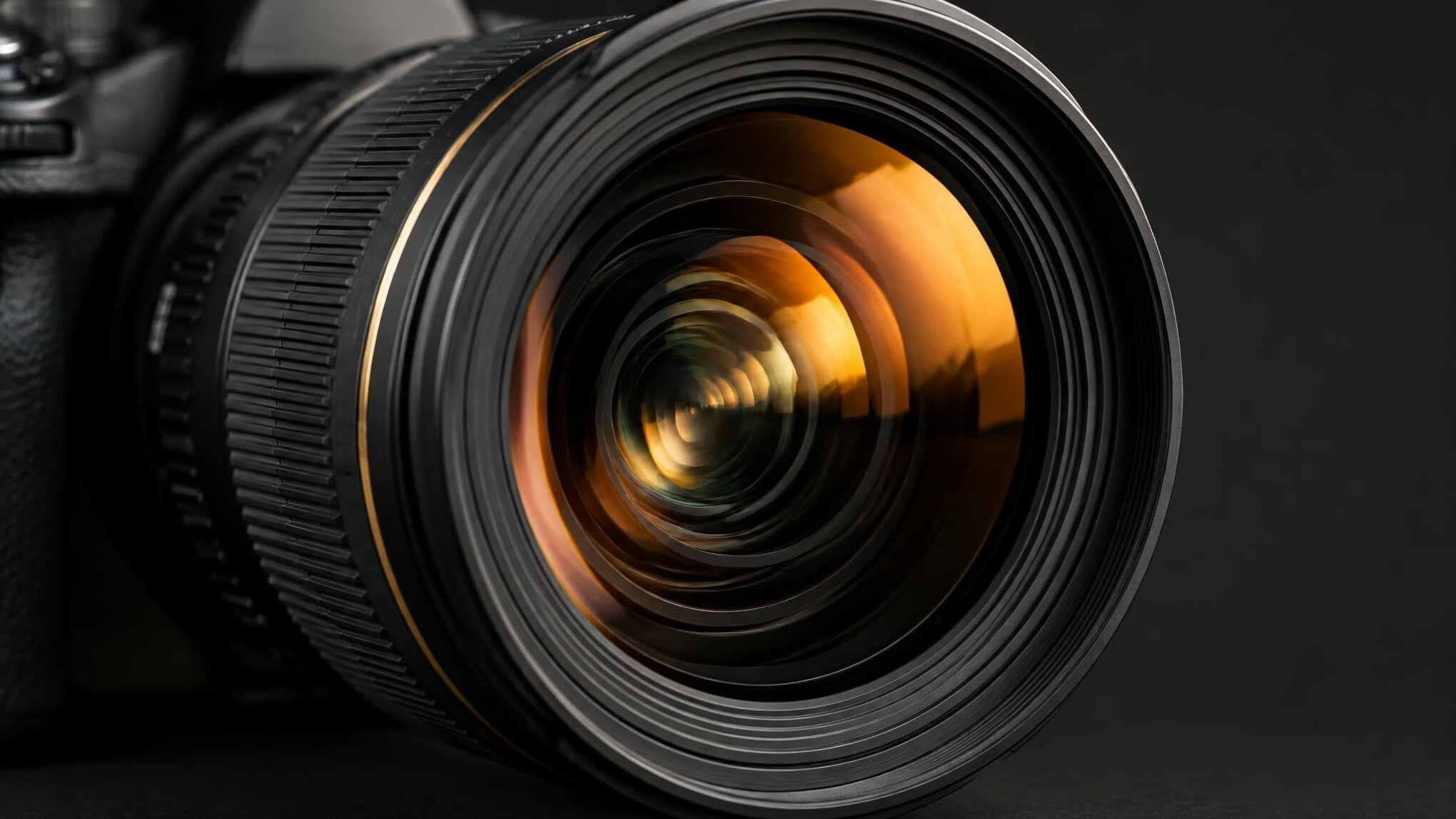 Close-up of a camera lens with warm reflections