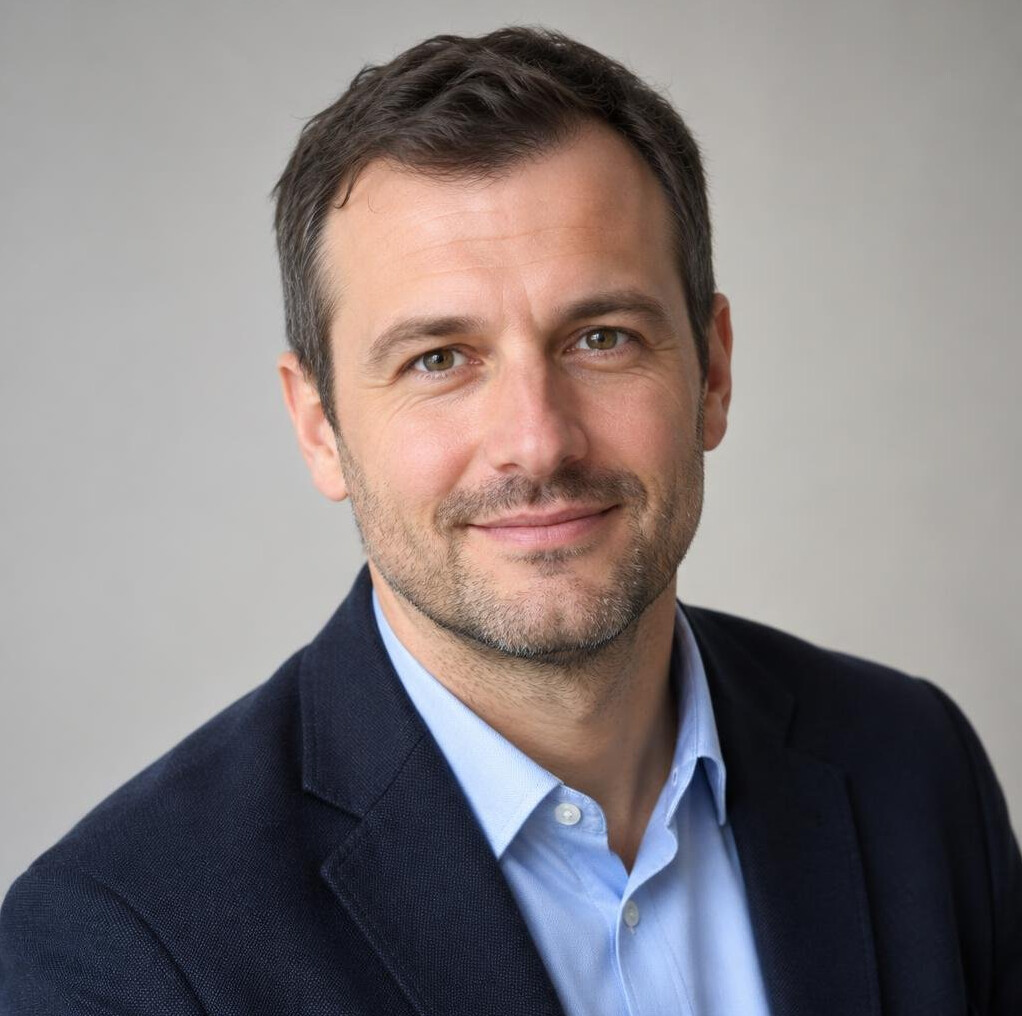 Portrait of a man in a dark jacket with a neutral background